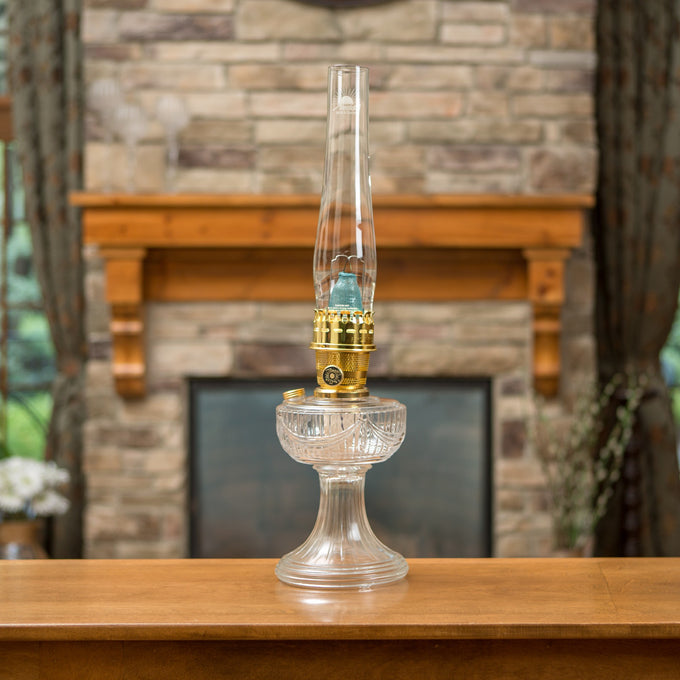 Clear antique-style oil lamp with USA-made glass base and brass burner, designed for Lamps & Lighting, Oil Lamps, Table Lamps, Best Sellers, and Promo Eligible collections.