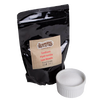 Resealable black pouch of food-grade sodium hydroxide lye beads with a white ceramic ramekin filled with pure white lye, featured in Health & Wellness and Soapmaking Supplies collections.