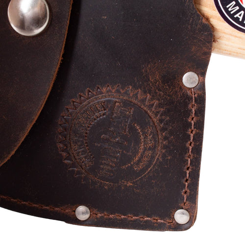 Close-up of a dark brown leather axe sheath with visible stitching, metal rivets, and an embossed circular logo, showcasing handcrafted Amish-made quality for outdoor and camping use.