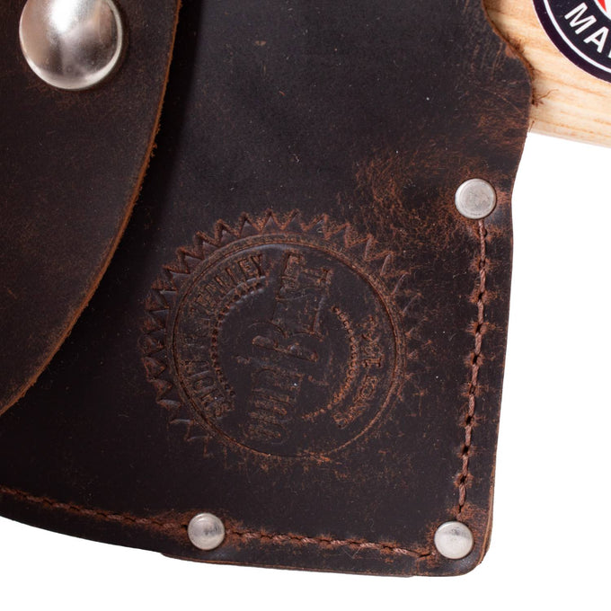 Close-up of a dark brown leather axe sheath with visible stitching, metal rivets, and an embossed circular logo, showcasing handcrafted Amish-made quality for outdoor and camping use.