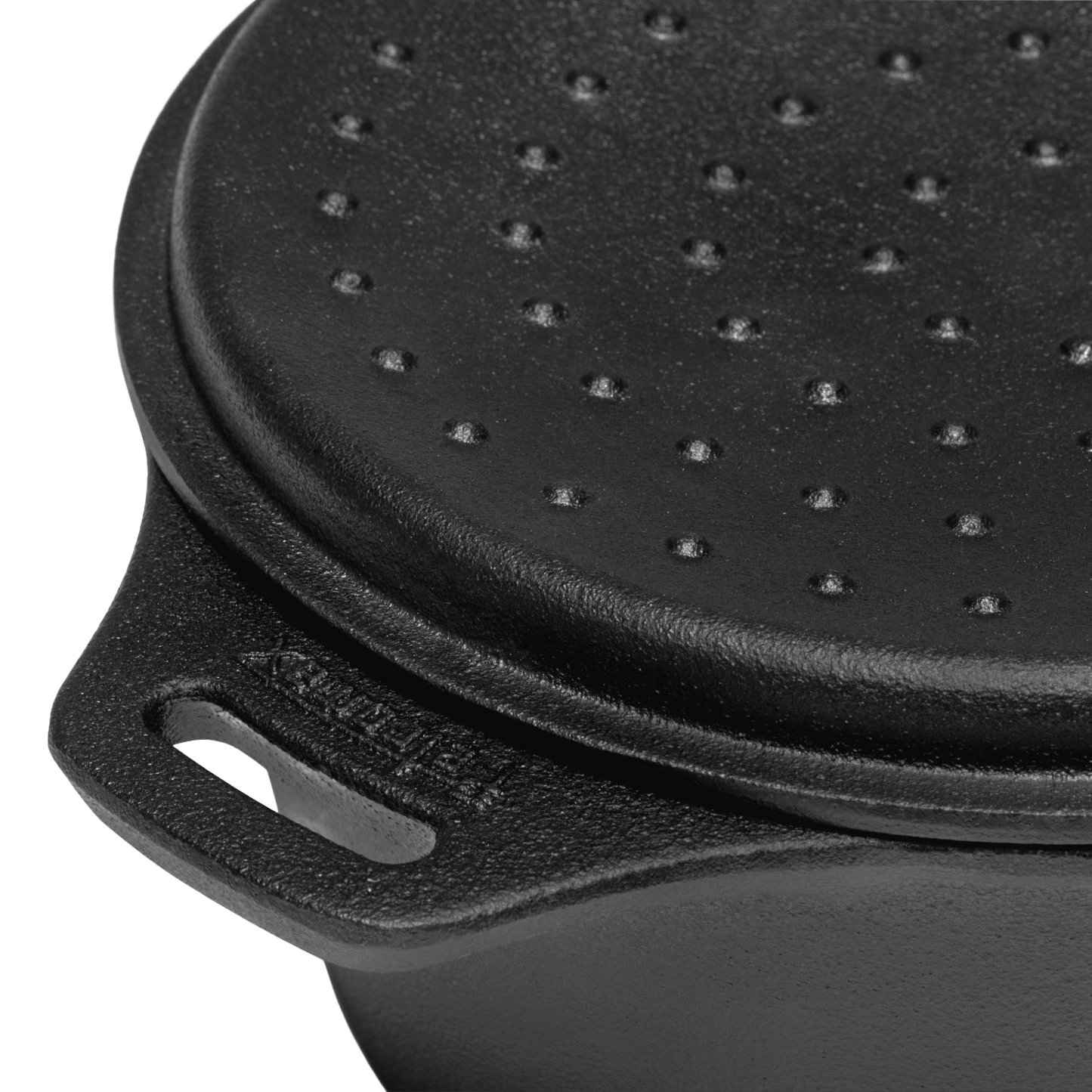 Close-up of the self-basting lid on a durable cast iron saucepan, featuring raised bumps and a sturdy handle, ideal for outdoor cooking in camping, farm, garden, and cookware collections.