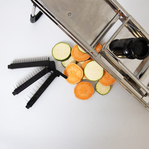 Stainless steel mandoline veggie slicer with interchangeable black blades and sliced zucchini and carrot rounds, designed for precision food prep in Kitchen & Food and Cooking Helpers collections.