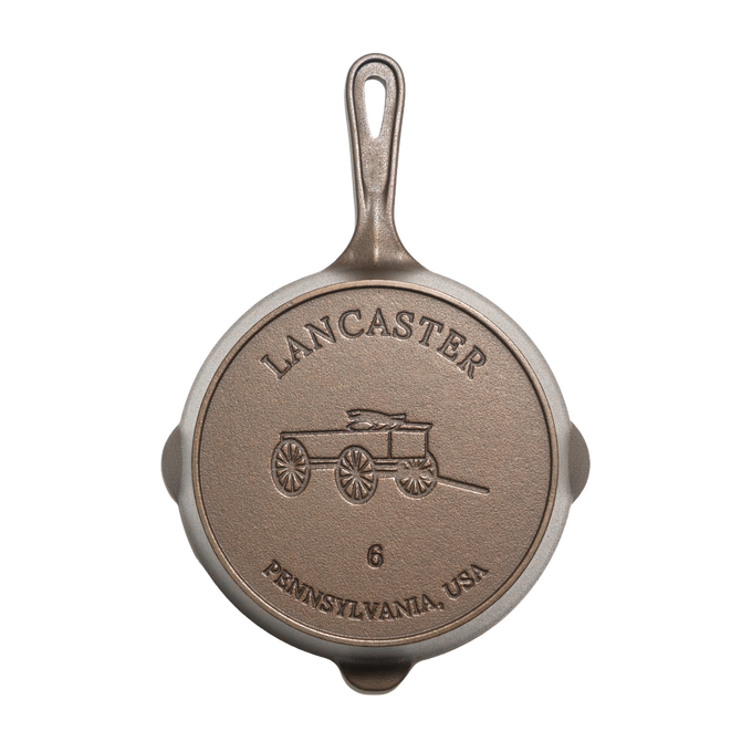 Bottom view of a handcrafted, lightweight cast iron skillet embossed with a horse-drawn wagon and marked size 6, made in the USA for Kitchen & Food, Camping, and Cast Iron collections.