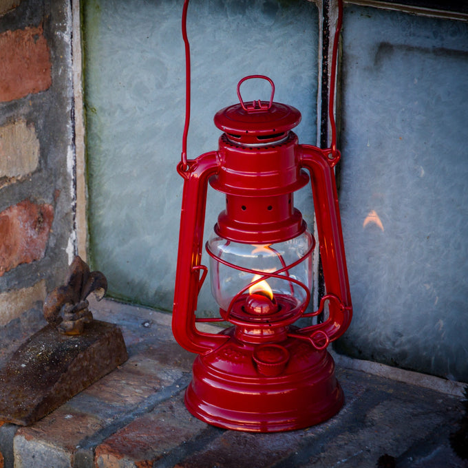 Handcrafted bright red galvanized oil lantern with sturdy construction and thermal heat-resistant globe, glowing warmly indoors, perfect for Camping, Lamps & Lighting, and Emergency Supplies collections.