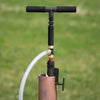 Handcrafted deep well hand pump with black foam handles and attached white hose, designed for easy installation in emergency water supply, made in USA, featured in Farm, Garden & Tool and Emergency Supplies collections.