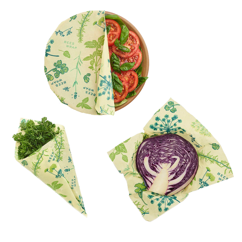 Set of three reusable beeswax food wraps in light yellow with green botanical prints, handcrafted in USA, ideal for eco-friendly kitchen storage and food preservation.