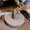 Artisan shaping wet clay on a pottery wheel, handcrafting a stoneware piece in a rustic workshop, highlighting handmade craftsmanship for Home & Decor and USA Made collections.