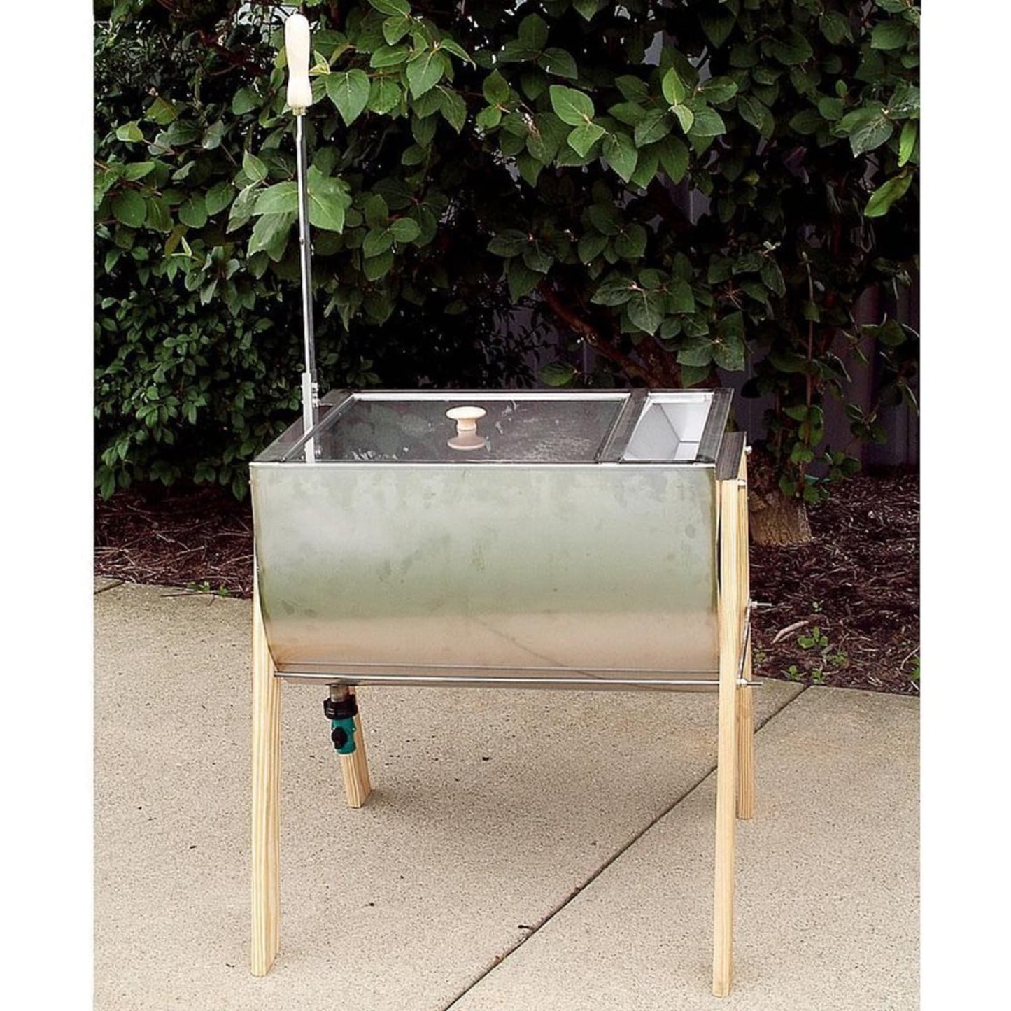 Metal hand washing machine with wooden legs and clear lid, featuring a crank handle and spout, crafted in USA for effective laundry use in home and decor settings.