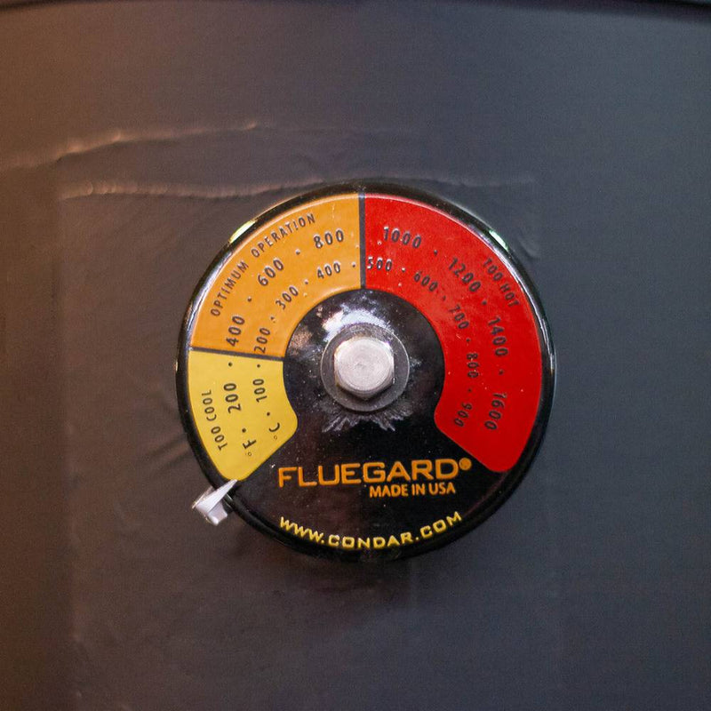 Round stove flue thermometer with color zones indicating temperature ranges from too cool to optimum and hot, featuring a USA-made design for Hearth Accessories and Stoves collections.