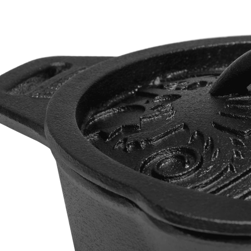 Close-up of a heavy-duty cast iron saucepan lid with raised, embossed self-basting pattern and sturdy handle, crafted for farm, garden, camping, and cookware collections.
