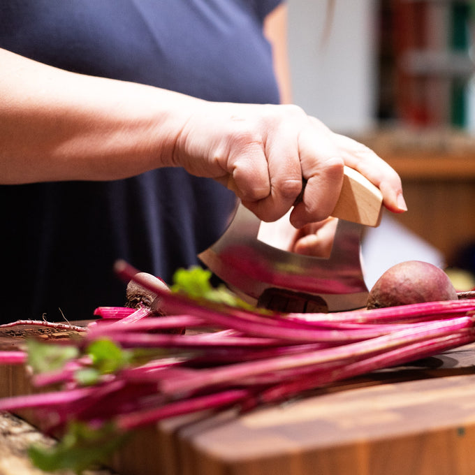 Handcrafted ulu knife with curved blade and wooden handle swiftly chopping fresh beet stems on wooden cutting board, ideal for Farm, Garden & Tool, Kitchen & Food, and Food Prep collections.