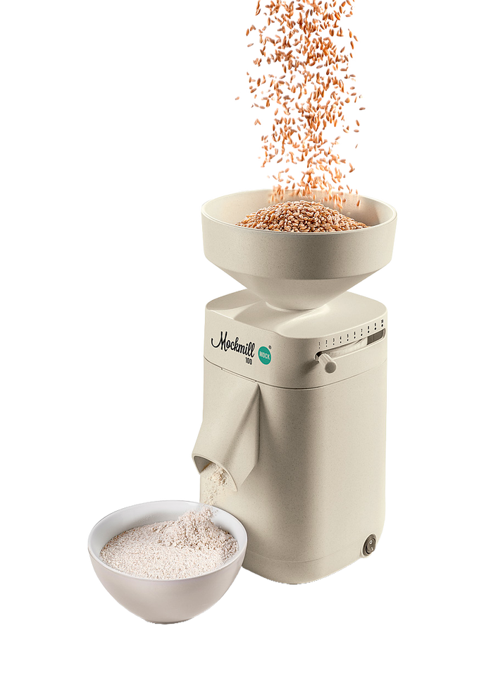 Electric stone grain mill in a smooth beige finish with large open hopper pouring wheat into the mill and fresh flour flowing into a white bowl, featured in Kitchen & Food, Grain Mills, Best Sellers, Promo Eligible, and New collections.