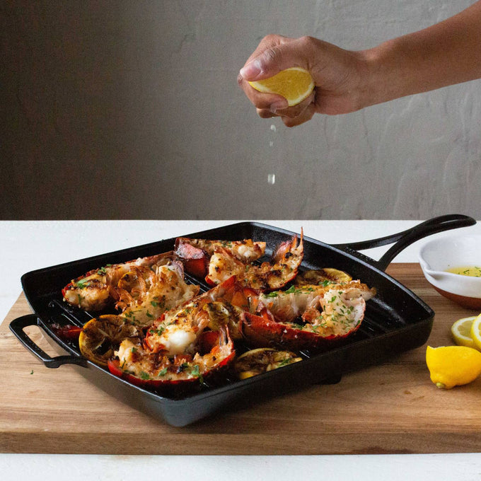 Square cast iron grill pan with grilled lobster tails and charred lemon halves, showcasing a handcrafted, triple-seasoned surface ideal for Kitchen & Food, Cookware, Cast Iron, USA Made collections.