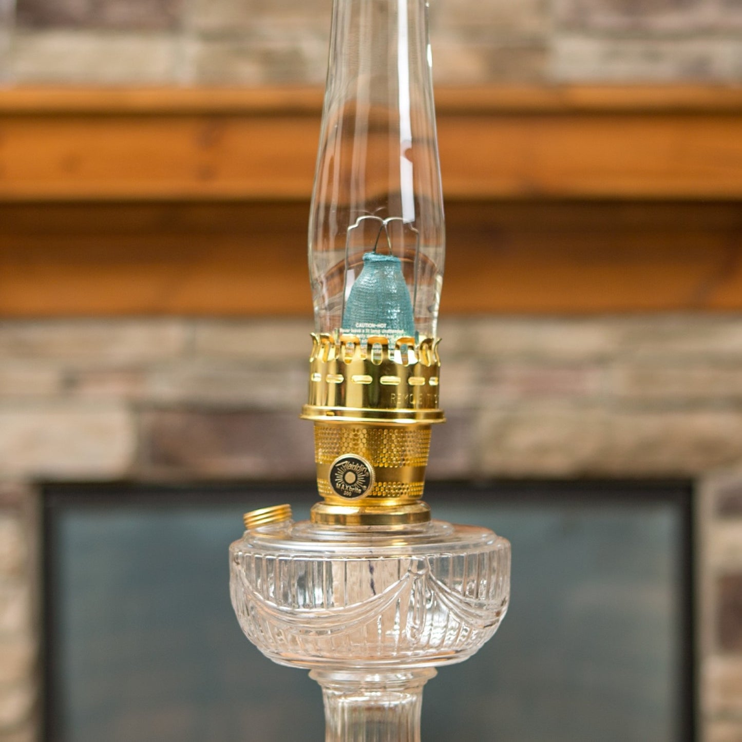 Clear glass oil lamp with brass burner and blue flame mantle, shown lit with a tall chimney, featured in Lamps & Lighting, Parts and Accessories, Wicks and Mantles, Lamp Burners and Collars, Best Sellers, and Promo Eligible collections.