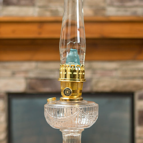 Clear glass oil lamp with brass burner and blue flame mantle, shown lit with a tall chimney, featured in Lamps & Lighting, Parts and Accessories, Wicks and Mantles, Lamp Burners and Collars, Best Sellers, and Promo Eligible collections.