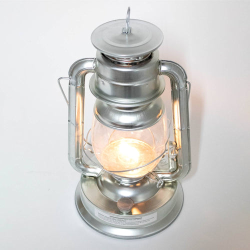 Handcrafted silver metal lantern emitting bright flame light through clear glass, designed for reliable use in Farm, Garden & Tool, Camping, Emergency Supplies, and Lamps & Lighting collections.