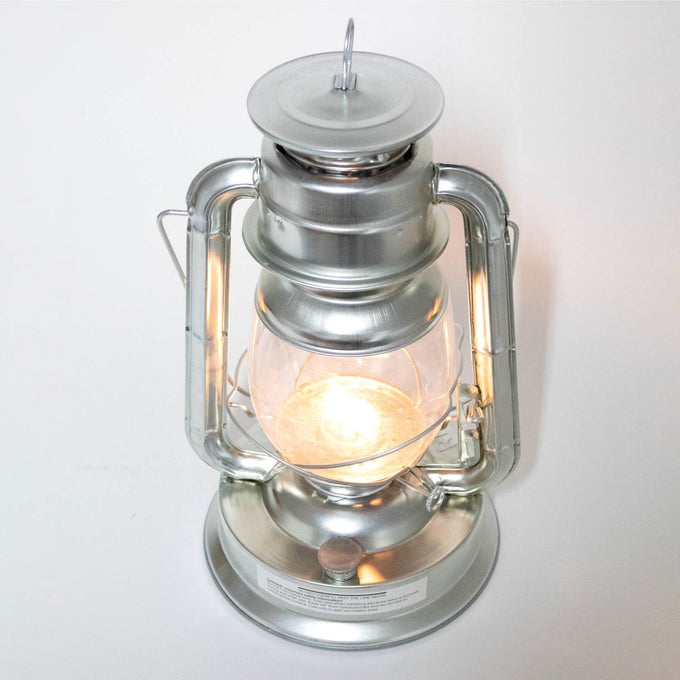 Handcrafted silver metal lantern emitting bright flame light through clear glass, designed for reliable use in Farm, Garden & Tool, Camping, Emergency Supplies, and Lamps & Lighting collections.