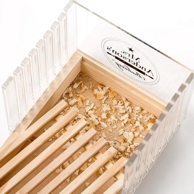 Handcrafted wooden bread slicing guide with clear acrylic panels and a removable crumb tray filled with fresh bread crumbs, featured in Kitchen & Food and Bread Making Supplies collections.