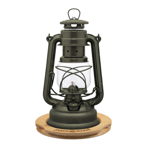 Unique handcrafted metal oil lantern with matte finish, positioned on a bamboo coaster engraved with matching logo, ideal for lamps, camping, emergency supplies, and outdoor use.