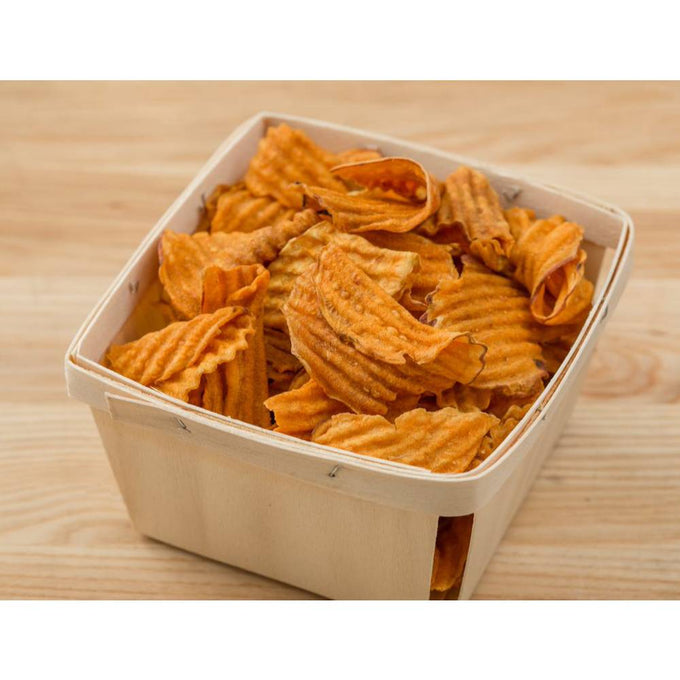 Square wooden basket filled with ridged sweet potato chips seasoned with sea salt, a gluten free snack from USA made food and kitchen collections