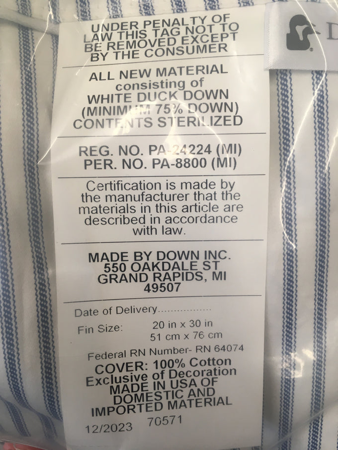 Close-up of a pillow tag detailing white duck down filling with minimum 75% down, sterilized contents, 100% cotton cover, made in USA, fitting Home & Decor, Home Textiles, Best Sellers, and Promo Eligible collections.