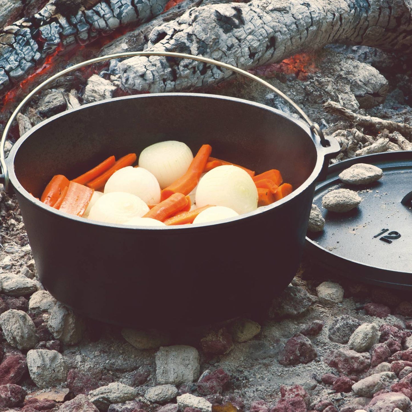 Handcrafted Lodge cast iron camp Dutch oven with built-in legs cooking whole onions and carrots over hot coals, ideal for Farm, Garden & Tool, Camping, Cast Iron, USA Made, Best Sellers, Promo Eligible collections.