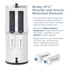 White water filter housing with two black optional reduction elements installed inside and two white replacement cartridges labeled with flow direction, used in water filtration for appliances, emergency supplies, and water treatment collections.