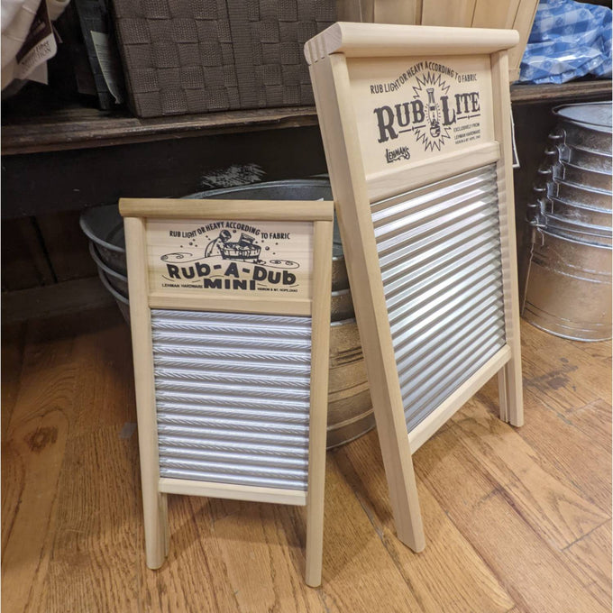 Two handcrafted wooden-framed tin spiral washboards with decorative printed nameplates, displayed on a wooden floor among rustic metal basins, from Home & Decor and Laundry Supplies collections.