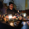 Handcrafted candle lanterns with warm glowing light illuminate an intimate outdoor dinner scene, highlighting wine glasses and rustic tableware, perfect for camping or home use.