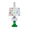 Handcrafted oil lamp with emerald green glass base and clear overlaid design, topped with festive parchment shade decorated with holly and poinsettia, featured in Lamps & Lighting and Table Lamps collections.