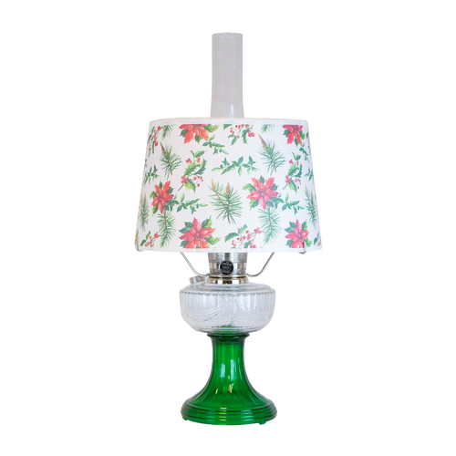Handcrafted oil lamp with emerald green glass base and clear overlaid design, topped with festive parchment shade decorated with holly and poinsettia, featured in Lamps & Lighting and Table Lamps collections.