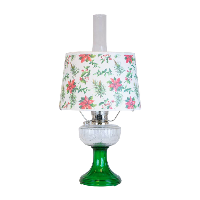 Handcrafted oil lamp with emerald green glass base and clear overlaid design, topped with festive parchment shade decorated with holly and poinsettia, featured in Lamps & Lighting and Table Lamps collections.
