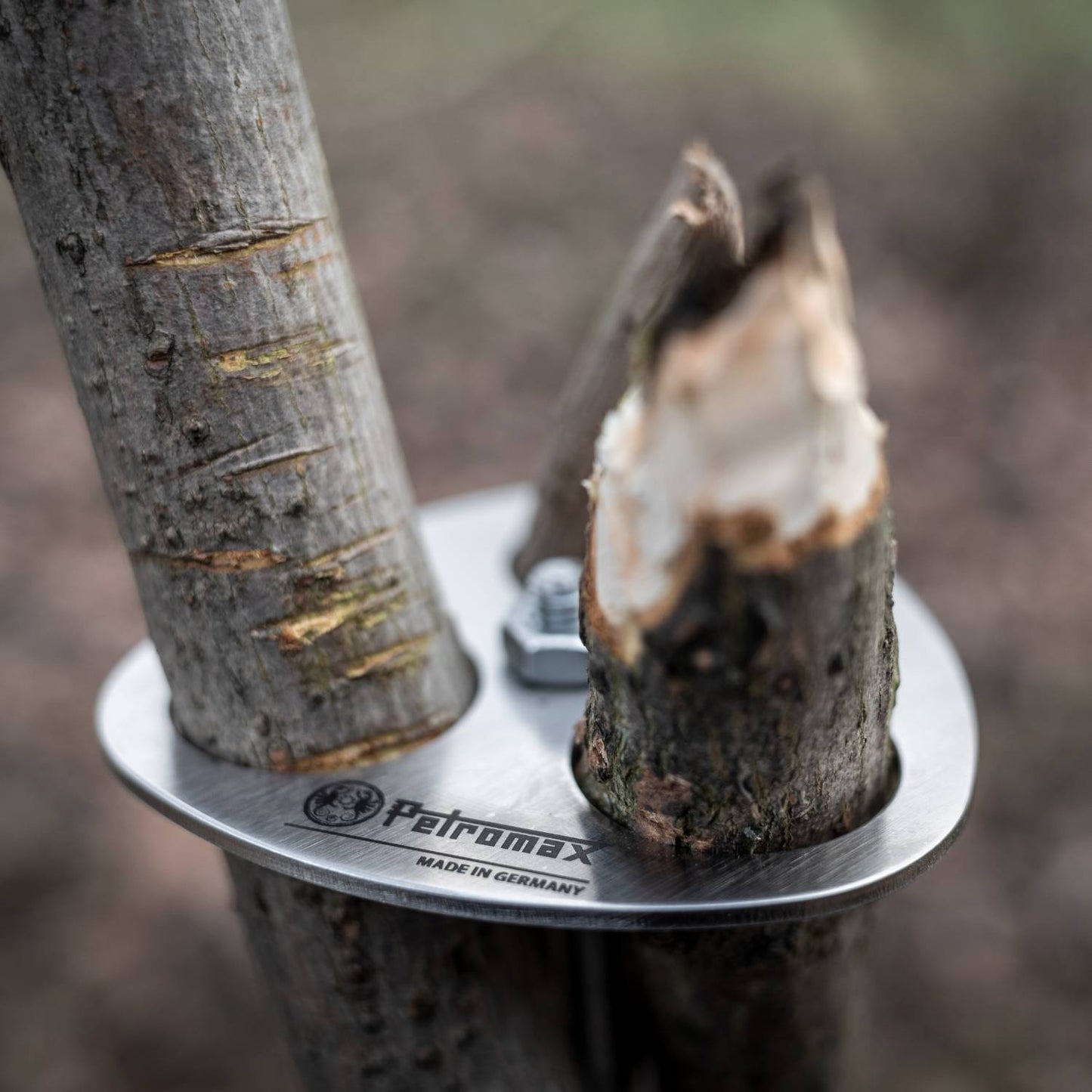 Close-up of a stainless steel tripod lashing disc secured around three natural wooden branches with a bolt, designed for use in Farm, Garden & Tool, Camping, Best Sellers, and Promo Eligible collections.
