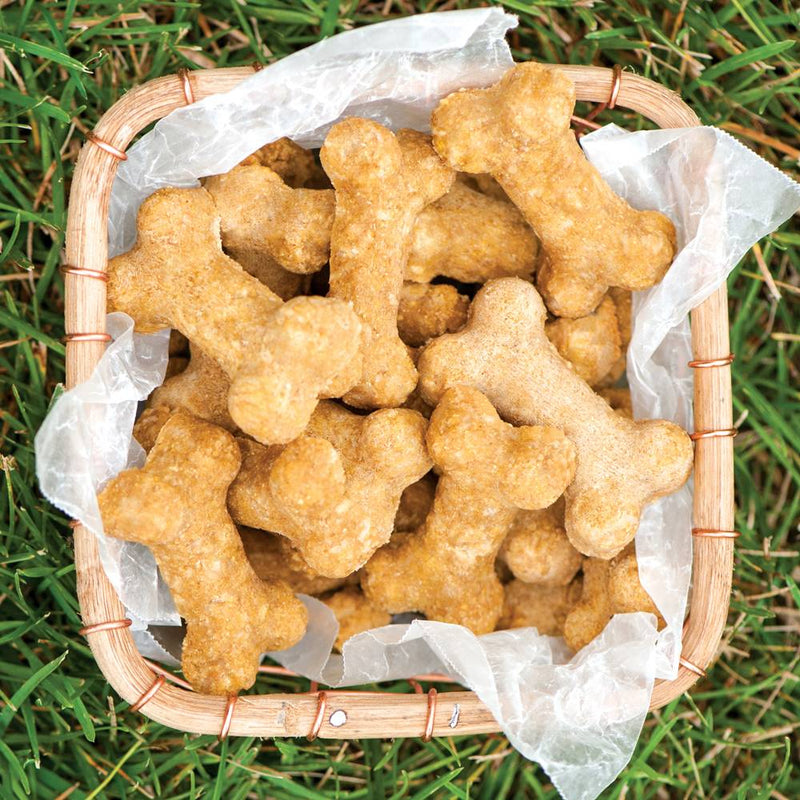 Basket filled with handcrafted bone-shaped dog treats made from a healthy mix, displayed on grass, suitable for Home & Decor, Pet Supplies, and Best Sellers collections.