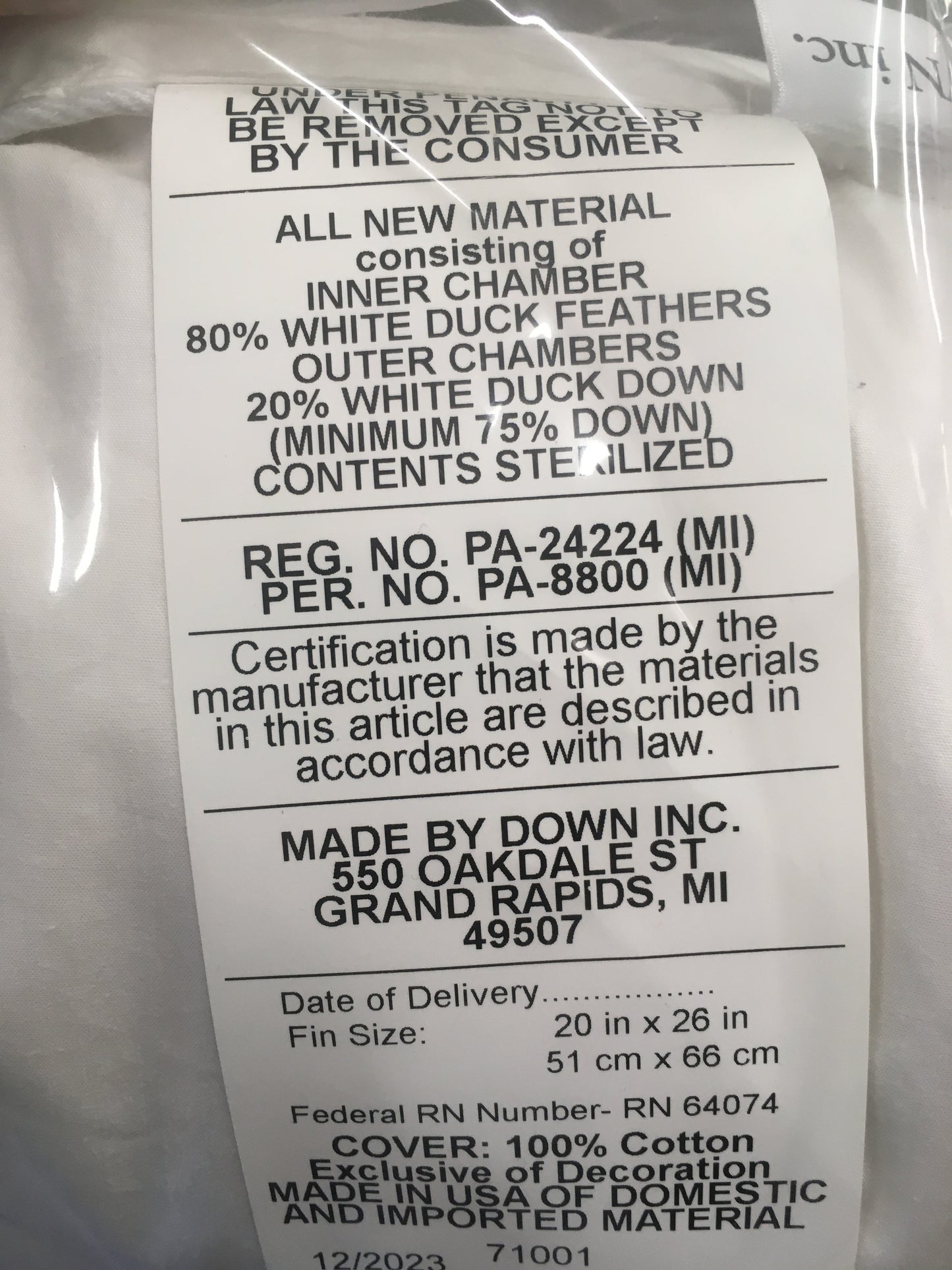 Close-up of a label on a layered feather and down pillow detailing 80% white duck feathers and 20% white duck down filling, with cotton cover, handcrafted in the USA, ideal for Home & Decor, Home Textiles, Best Sellers, and Promo Eligible collections.