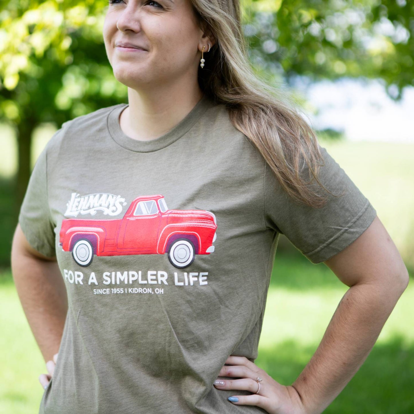 Adult wearing olive soft cotton t-shirt featuring a vintage red truck graphic with "For a Simpler Life" slogan, part of Lehman's Clothing and Accessories, Health & Wellness, and Best Sellers collections.