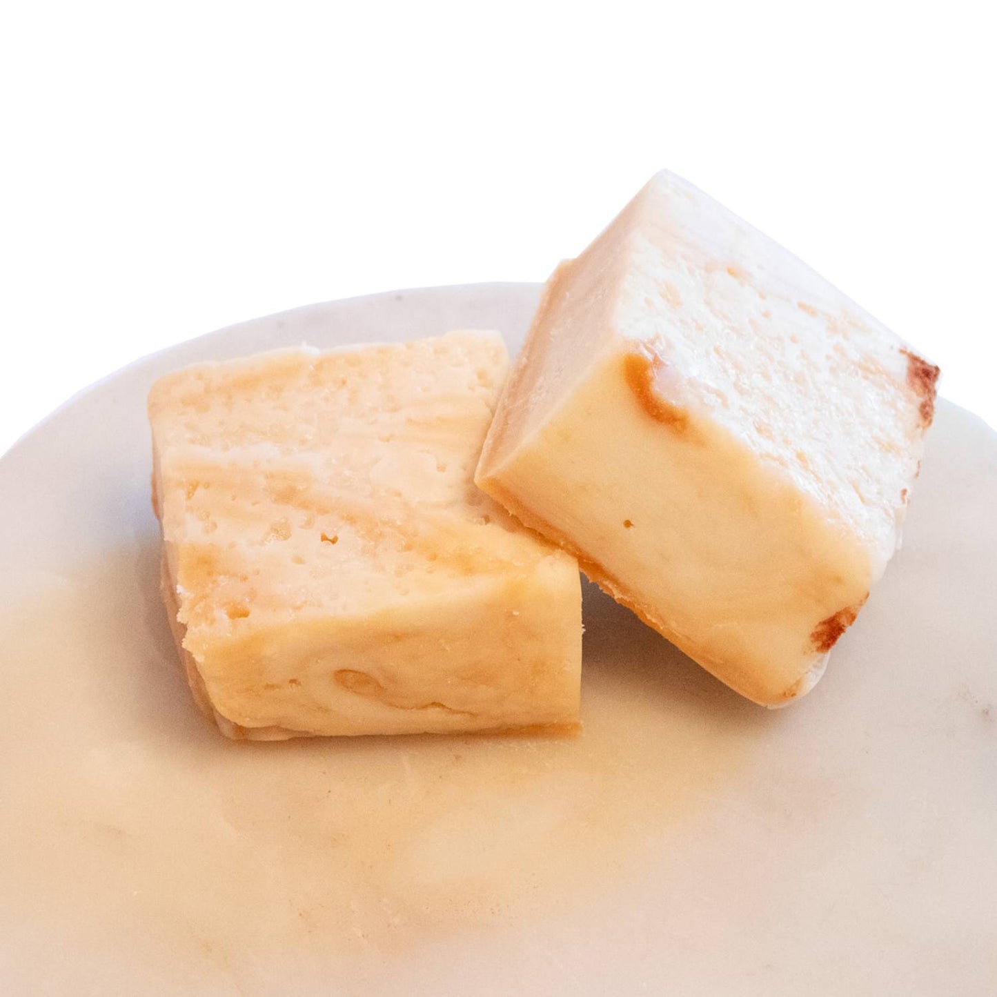 Two handcrafted creamy beige fudge pieces with a smooth, melt-in-your-mouth texture on a light marble plate, featured in Kitchen & Food, Snacks and Sweets, USA Made, and Best Sellers collections.