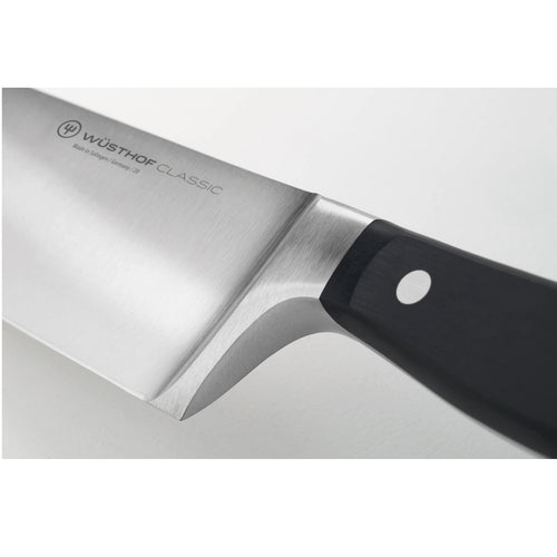 Close-up view of a high carbon stainless steel chef’s knife with a sturdy black handle triple-riveted for durability, ideal for kitchen knives, food prep, and farm tools.