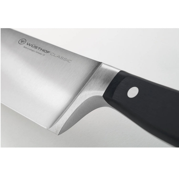 Close-up view of a high carbon stainless steel chef’s knife with a sturdy black handle triple-riveted for durability, ideal for kitchen knives, food prep, and farm tools.