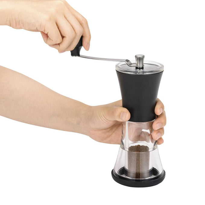 Hands holding and turning a slim adjustable coffee grinder with a ceramic mechanism, featured in Kitchen & Food, Brewing Coffee and Tea, and Kitchen Gadgets collections.