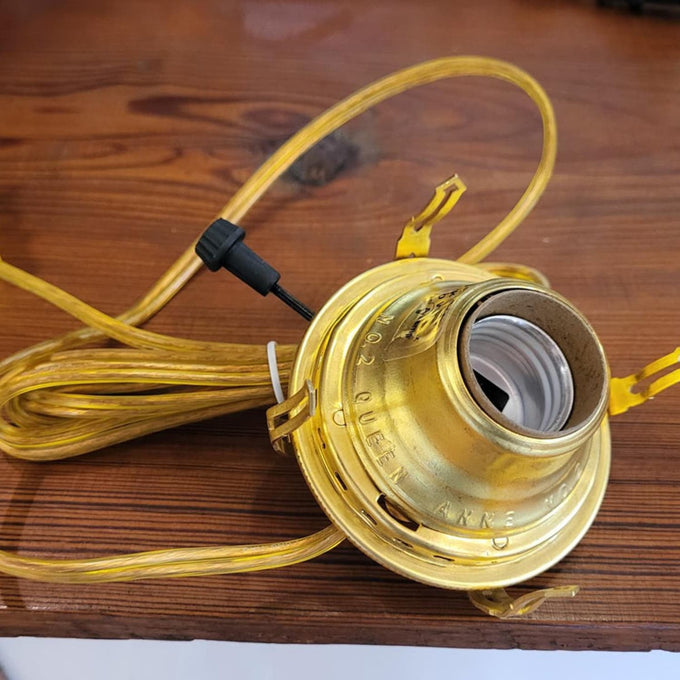 Solid brass electric lamp burner with 1-3/16" threaded base, embossed #2 Queen Anne, equipped with UL listed parts and clear gold cord, part of Lamps & Lighting and Electric Conversion collections.