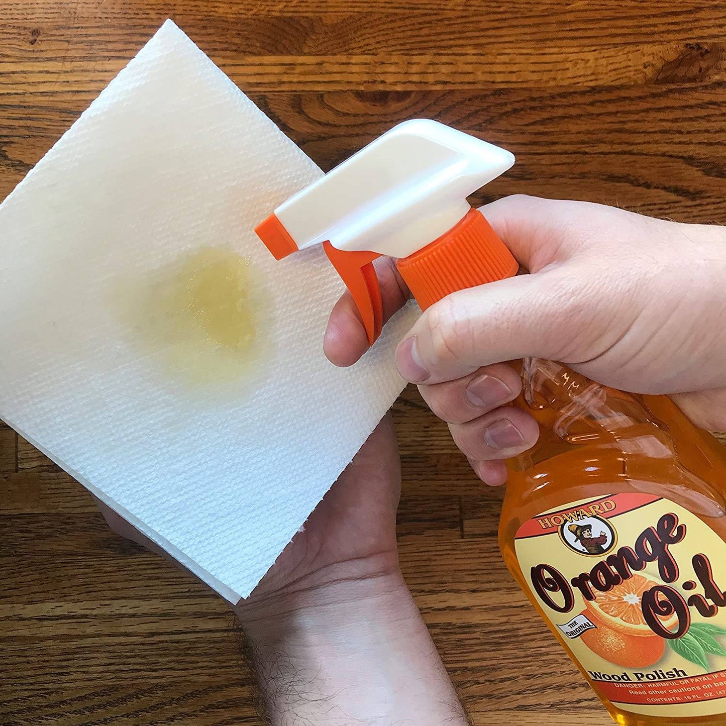 Handcrafted spray bottle of orange oil wood polish being applied onto a white cloth, ideal for conditioning and enhancing wood surfaces in Home & Decor and Household Cleaning collections.