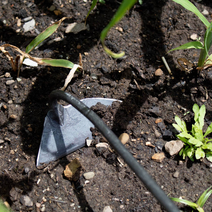 Handcrafted steel blade on a slender metal shaft slicing beneath soil surface among plants, designed for precise weed removal in Farm, Garden & Tool, Garden Accessories, Best Sellers, Promo Eligible collections.