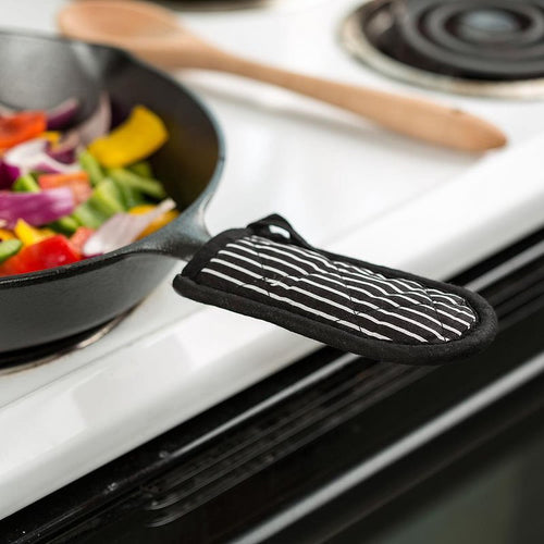 Black and white striped padded handle cover fitted on a cast iron skillet handle, designed to protect hands from heat up to 350°F, featured in Kitchen & Food, Cast Iron, Cookware, and Best Sellers collections.