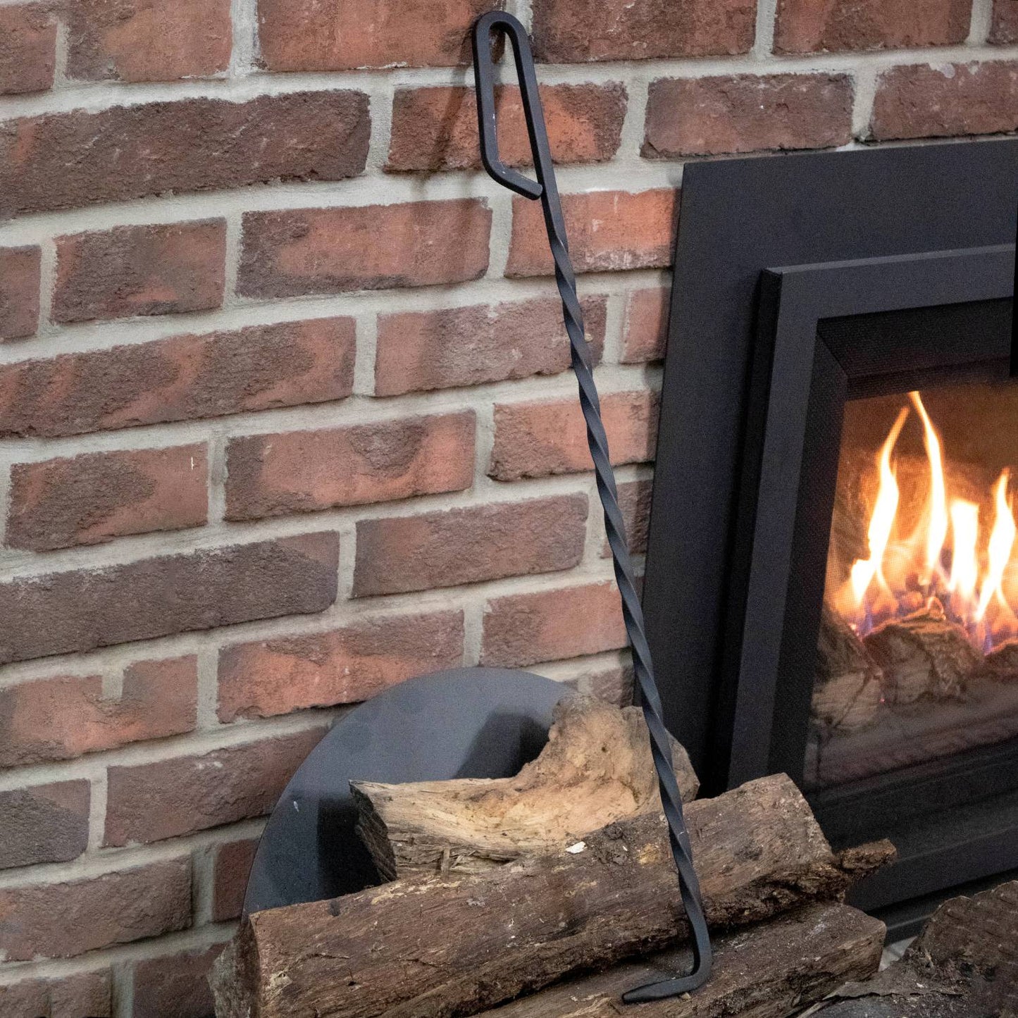 Handcrafted steel fire poker with a twisted shaft and loop handle, Amish made in USA, designed for safely adjusting logs and stirring embers in home fireplaces and hearth accessories.
