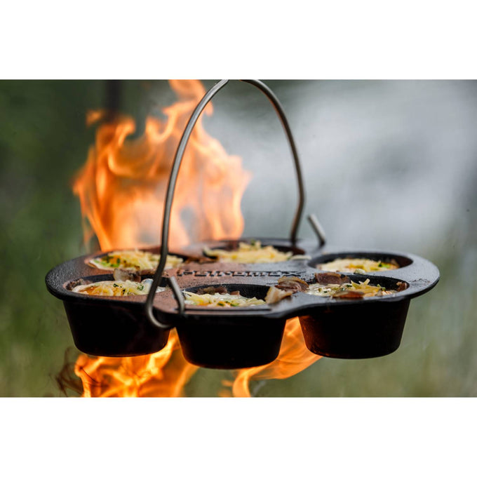 Cast iron muffin pan with six sections cooking savory muffins over an open flame, featuring sturdy design perfect for Farm, Garden & Tool, Kitchen & Food, Camping, Cast Iron, and Best Sellers collections.