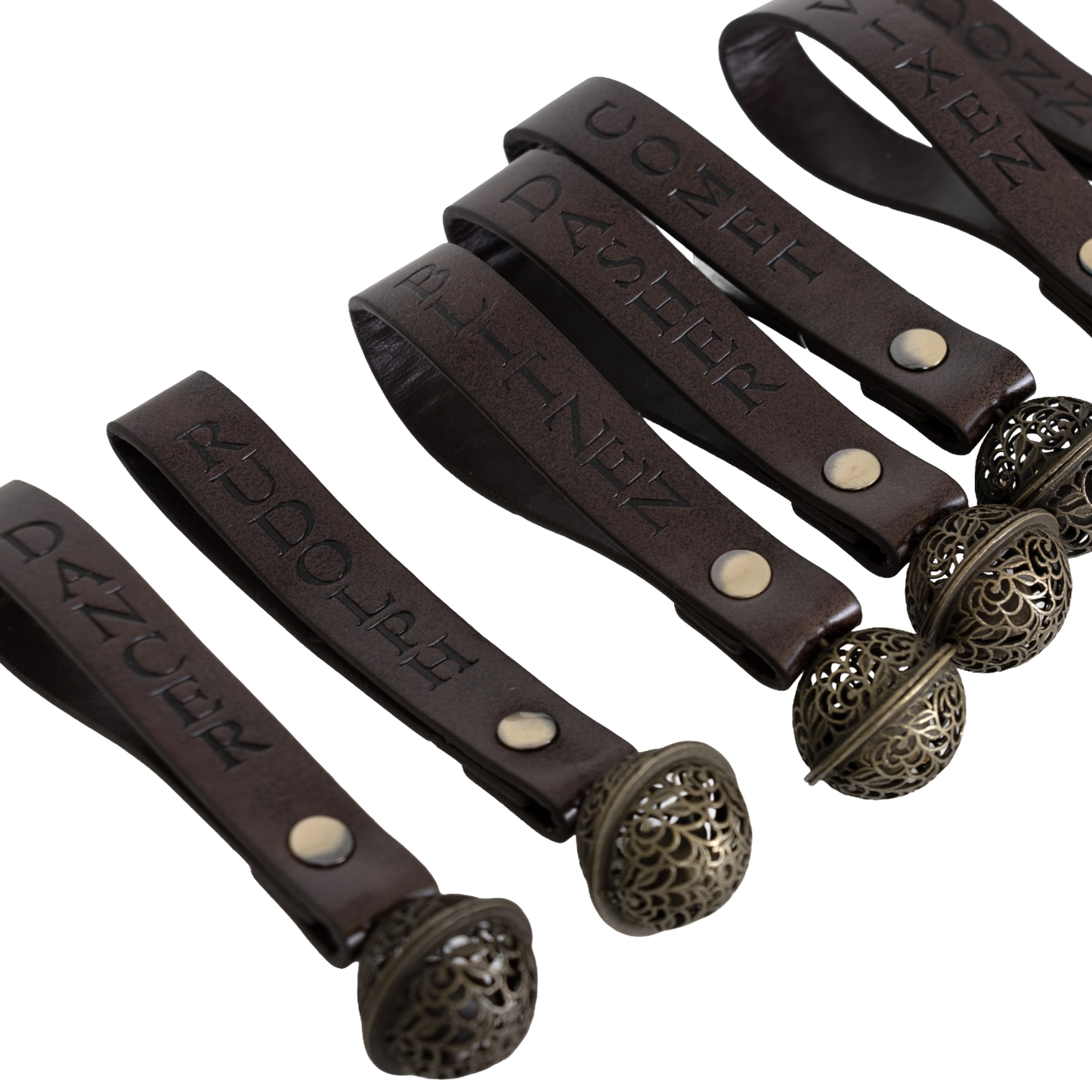 Set of nine handcrafted ornament bells with engraved brown leather straps featuring names of Santa’s reindeer, adorned with intricate metal bell accents for Home & Decor, Holiday Decor, and Best Sellers collections.