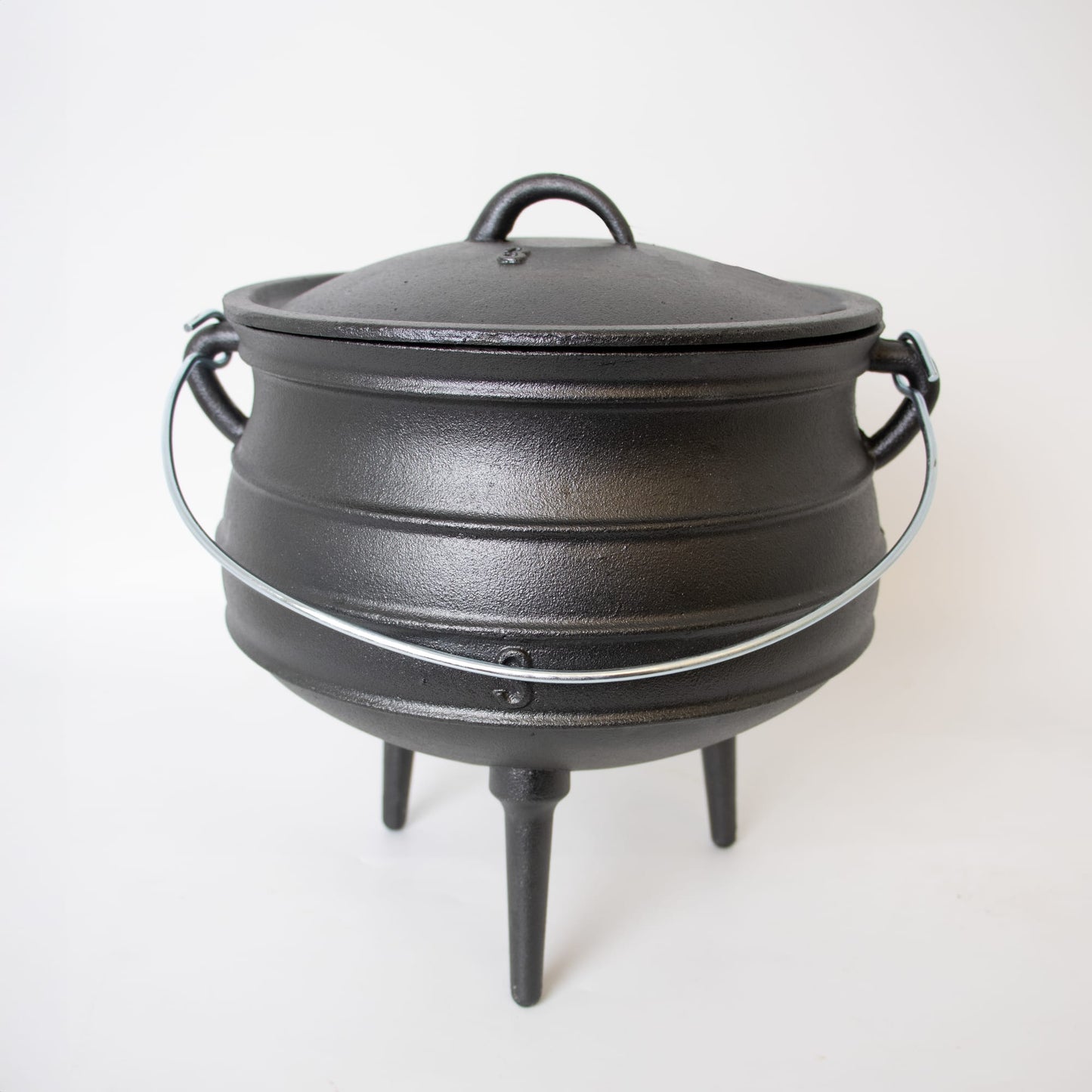 Round handcrafted cast iron campfire kettle with three sturdy legs, a fitted lid, and a metal bail handle, designed for durable outdoor cooking in Farm, Garden & Tool, Camping, Best Sellers, and Promo Eligible collections.