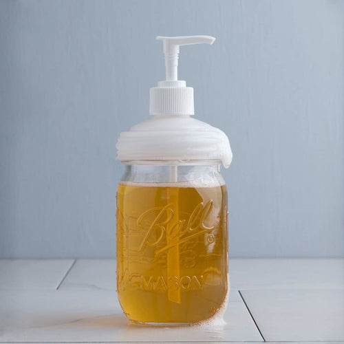 Clear glass regular-mouth jar filled with amber soap and topped with a white pump lid, showcasing a reusable, USA made dispenser ideal for Health & Wellness, Home & Decor, and Household Helpers collections
