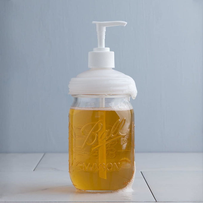 Clear glass regular-mouth jar filled with amber soap and topped with a white pump lid, showcasing a reusable, USA made dispenser ideal for Health & Wellness, Home & Decor, and Household Helpers collections